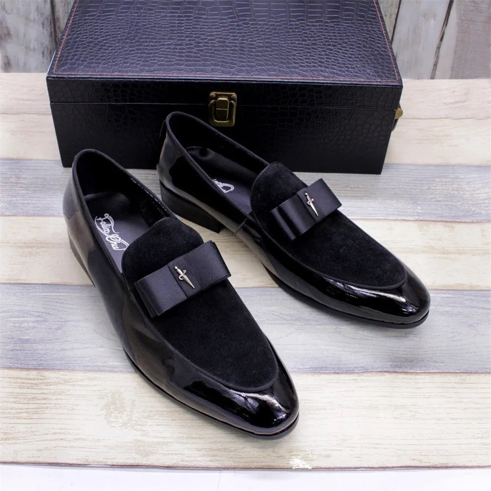 Men's black patent leather shoes with a gold tassel detail on a rubber sole.