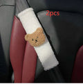 Plush cartoon bear car seat belt shoulder cover in khaki colour, shown next to a car seat.