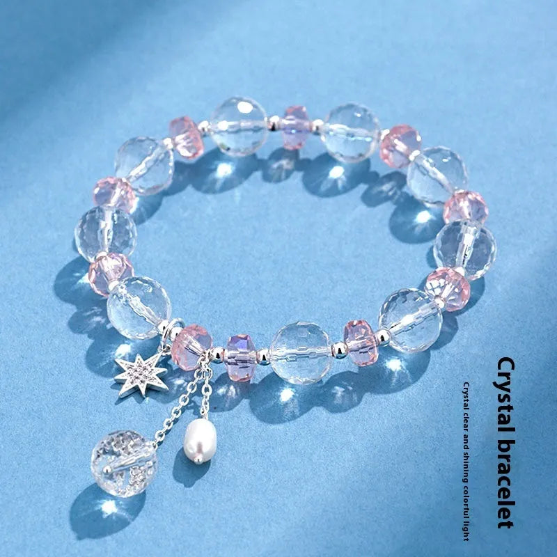 Women's white crystal bracelet with diamond shapes and lucky cat charm on wrist