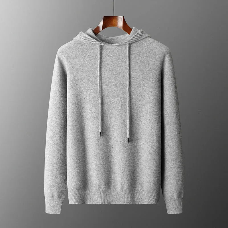Man wearing a light grey cashmere hooded sweatshirt and matching trousers, a casual winter two-piece set.