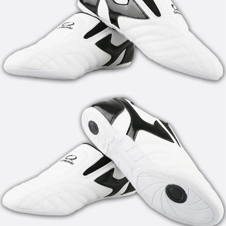 Black and white children's Sanda Taekwondo martial arts shoes with a soft sole and widened fit.