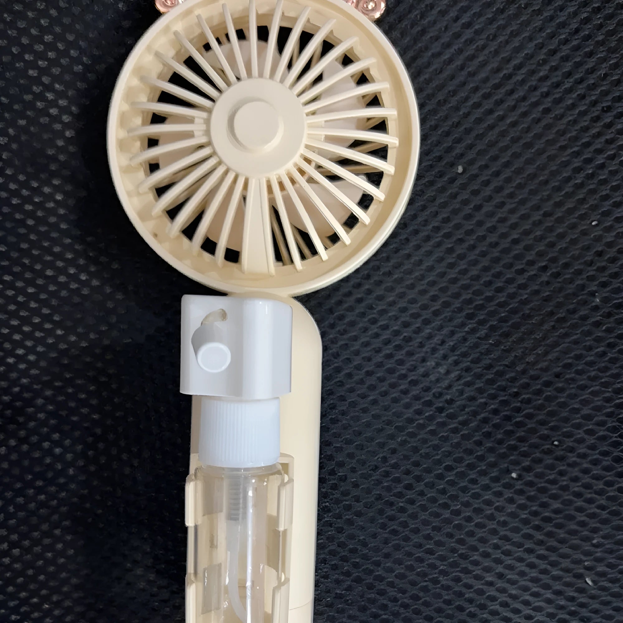 Coloured plastic USB rechargeable personal fan on a desk