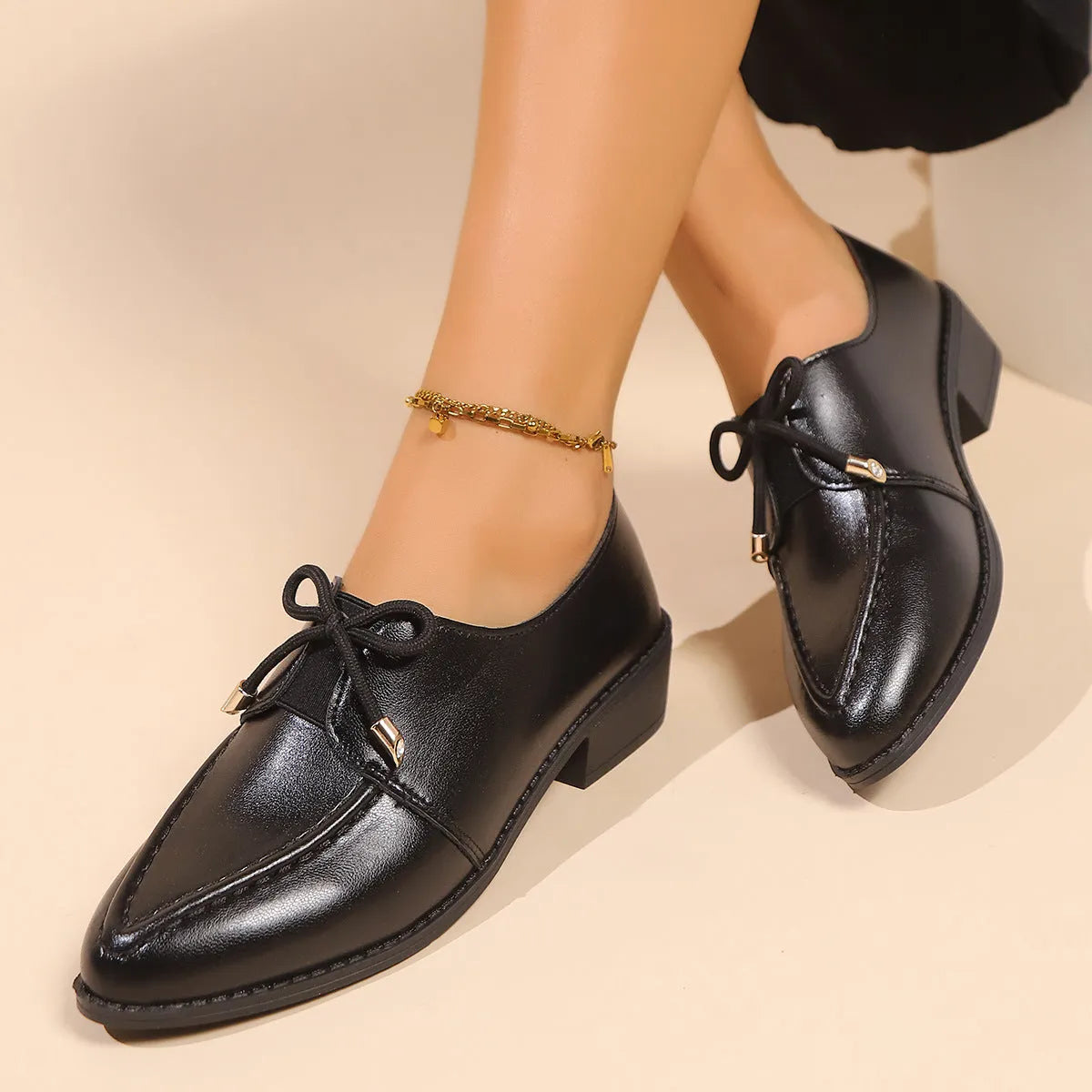 Women's simple leather-look flat shoes with a decorative bow, shown in slip-on style with a rubber sole.