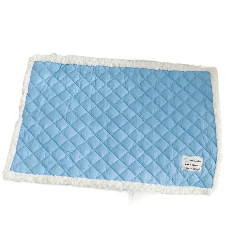Quilted blue terry cloth pet blanket for cats shown on a pet bed.
