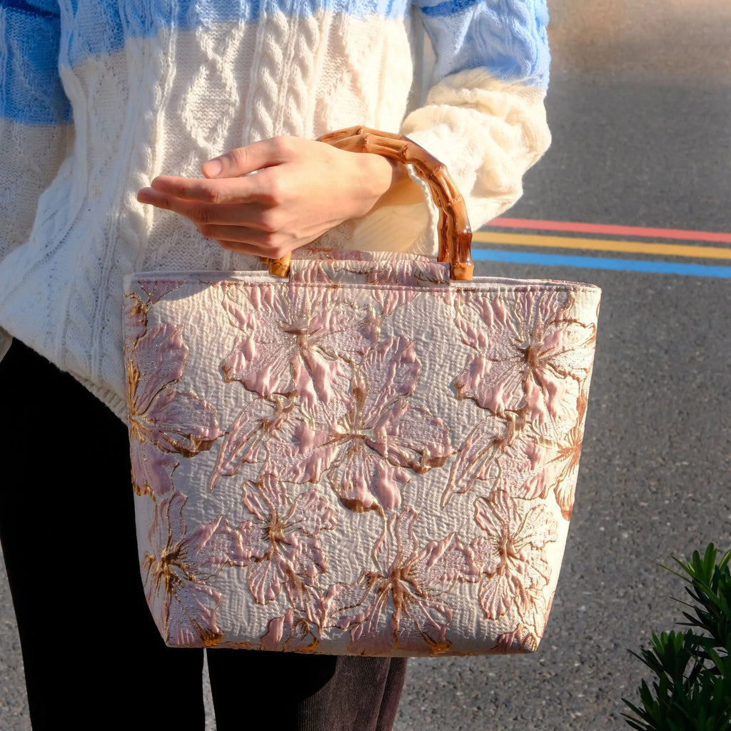 Light blue canvas shoulder bag with bronzing flower print, square shape, and two adjustable connector straps