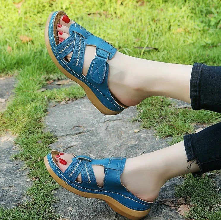 Women's black wedge sandals with a peep toe and Velcro fastening strap on a white background.