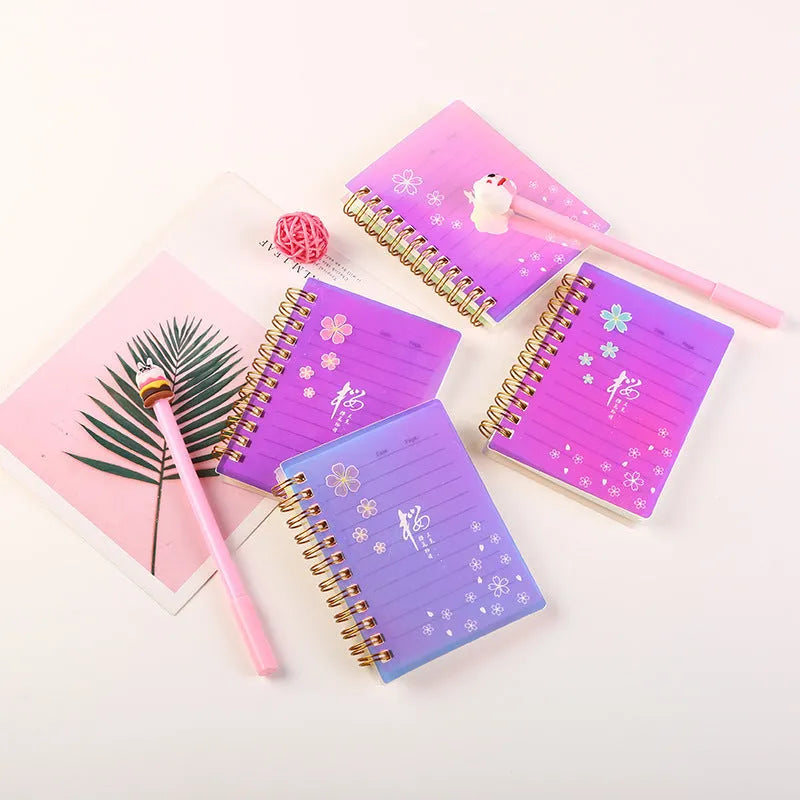 Set of four A7 spiral-bound pocket notebooks with rollover coils, showing Constellation, Sakura, Ocean, and Universe cover designs.