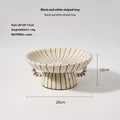 Black and white striped retro style synthetic resin fruit plate on a wooden surface.
