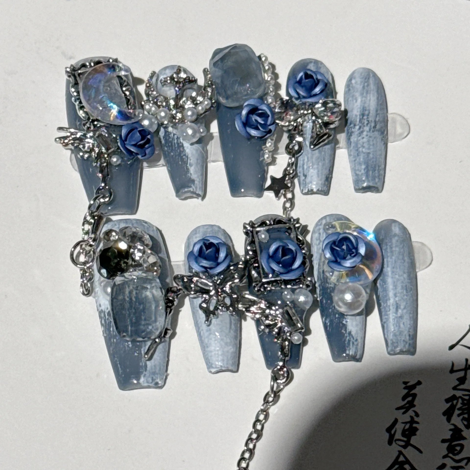 Blue false nails with rose and flower pattern, shown in a set with sizes XS, S, M, L.