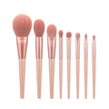 8-piece pink makeup brush set with man-made fibre bristles and plastic handles on white background