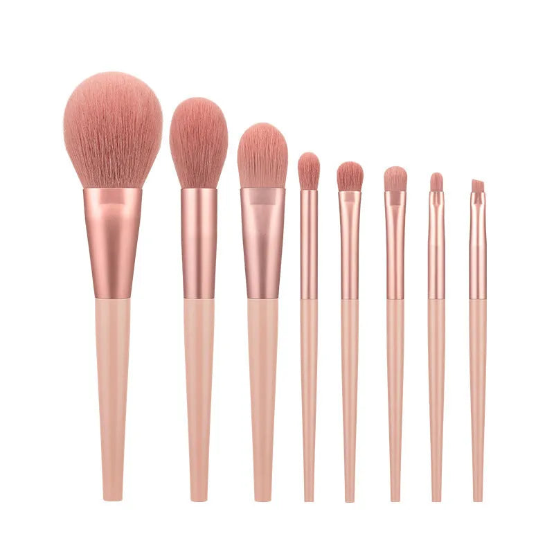 8-piece pink makeup brush set with man-made fibre bristles and plastic handles on white background