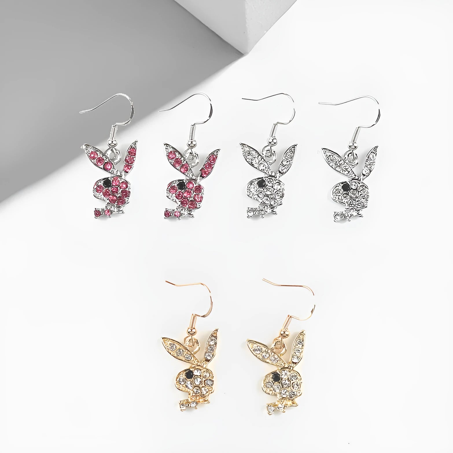 Close-up of rabbit-shaped alloy stud earrings in gold, pink, and silver colour options.