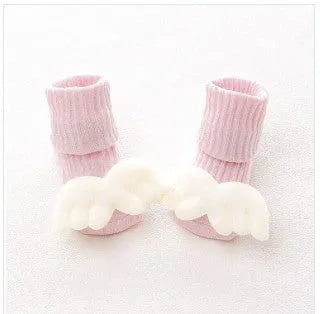 Cotton baby floor socks in a pink bow pattern, shown on an infant's feet.