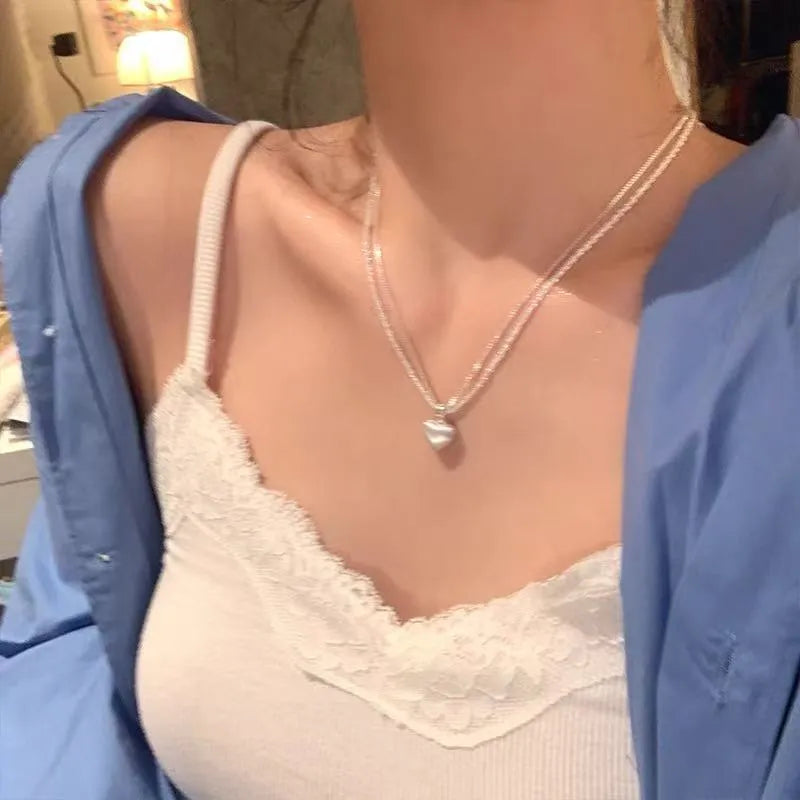 Women's brushed silver double-layer heart pendant necklace on an adjustable chain.