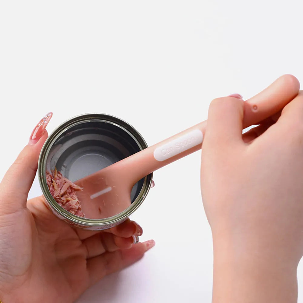 Green pet feeding spoon with long handle and right-angle edge for scraping canned dog or cat food.