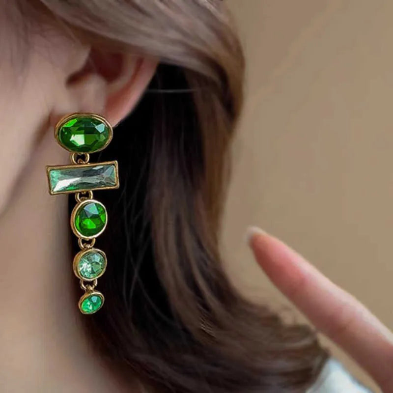 A pair of green gradient retro earrings with a geometric shape, tassel detail, and zircon inlay on an alloy base.