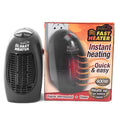 Black compact ceramic electric heater with digital display and a rotating plug on a desk.