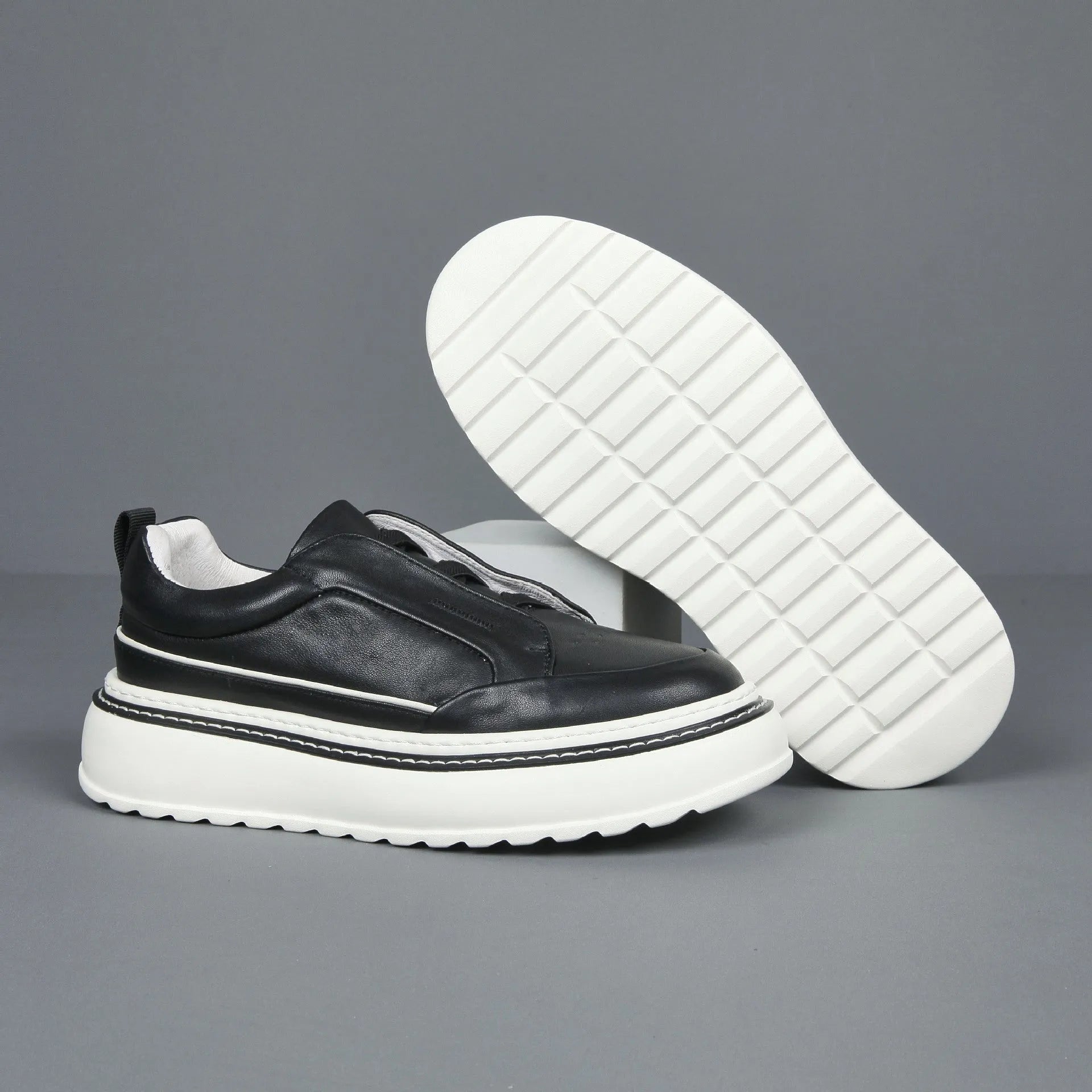 Breathable casual slip-on sneaker in black with first layer cowhide upper, platform mid heel, and sewing thread detail