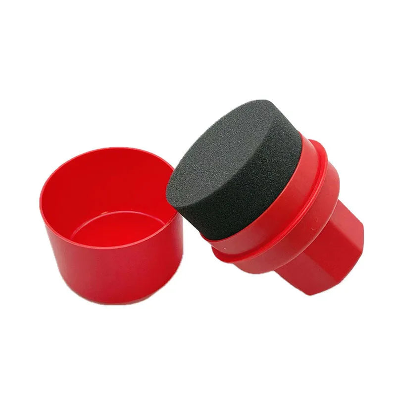 Black and red car tyre polishing sponge brushes with lids on a workbench.