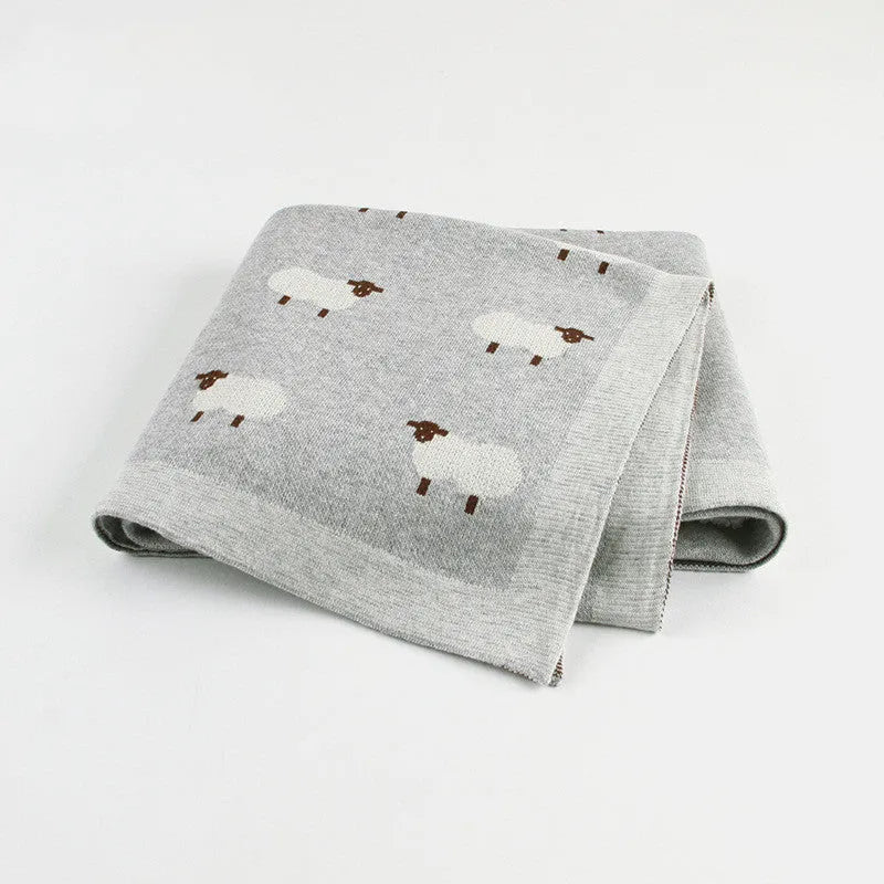 A pink baby sheepskin blanket measuring 100 by 80 cm on a pram.
