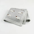 A pink baby sheepskin blanket measuring 100 by 80 cm on a pram.