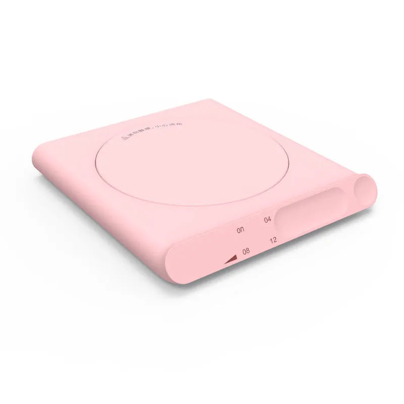 Pink and white USB heating cup pad or mug warmer with mechanical controls on a desk.