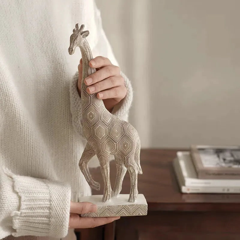 Tall wooden-coloured giraffe resin figurine ornament on a surface.