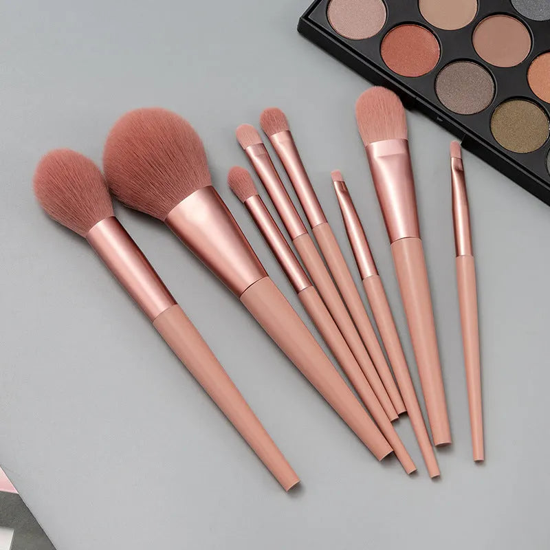 8-piece pink makeup brush set with man-made fibre bristles and plastic handles on white background