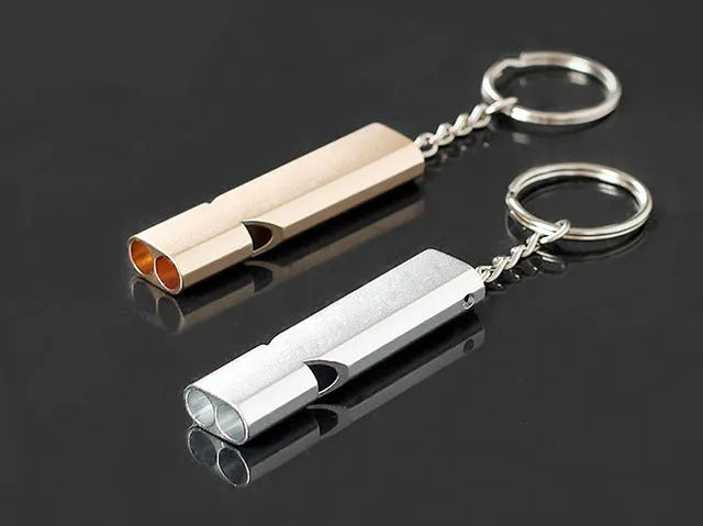 Silver or gold coloured aluminium alloy double hole outdoor survival whistle.