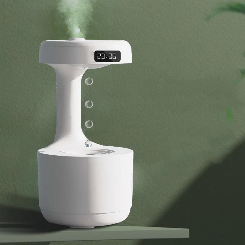 White columnar anti-gravity humidifier with LED clock display emitting mist on a wooden desk.