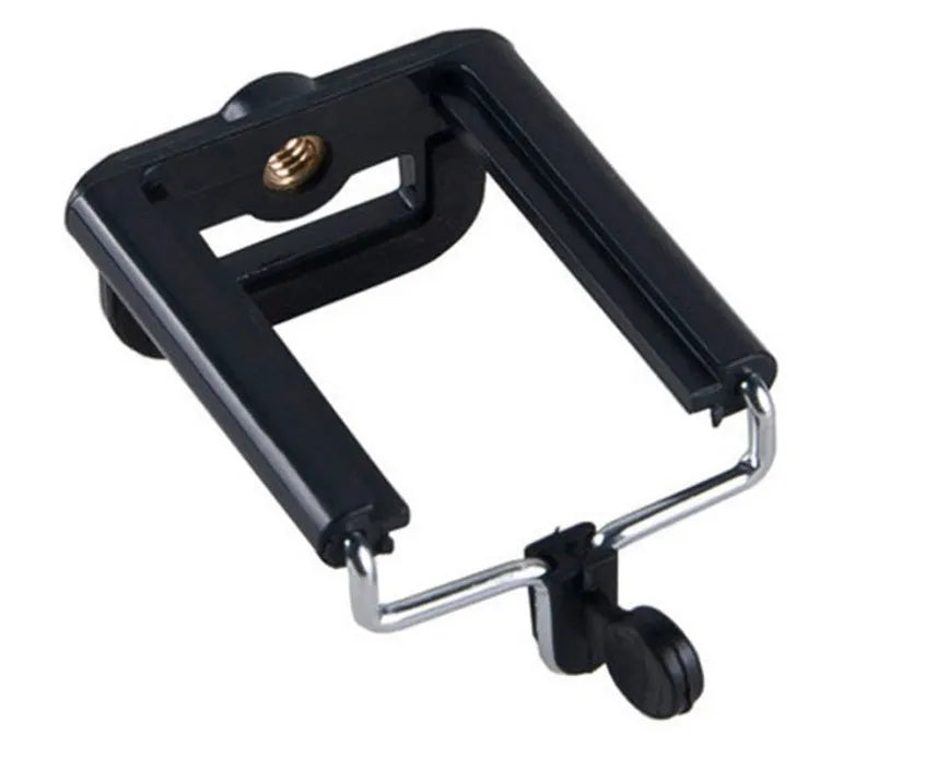 Black mini flexible tripod extended on a table with a silver U-shaped phone clip attached.