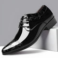Glossy black men's business formal shoes with patent finish, pointed toe, and carved detail on a neutral background