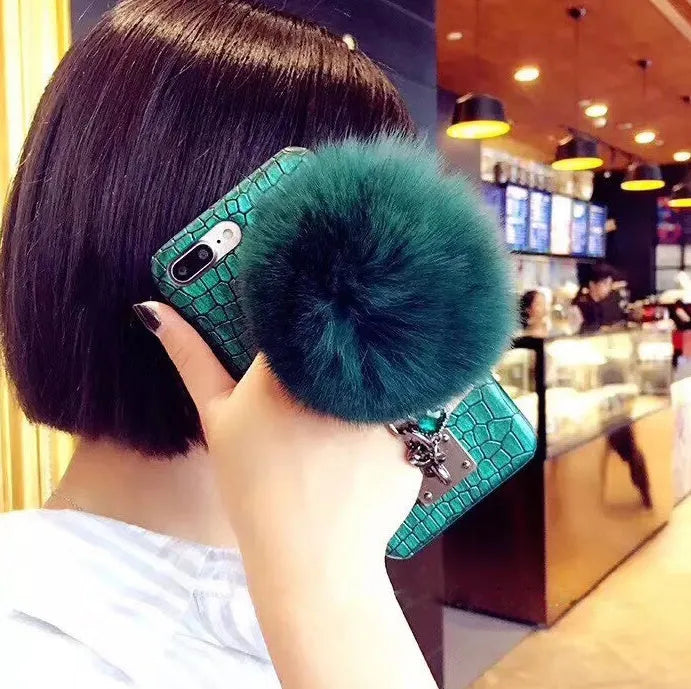 Red iPhone case with rhinestone decoration and attached fox fur ball showing Japanese Korean style design