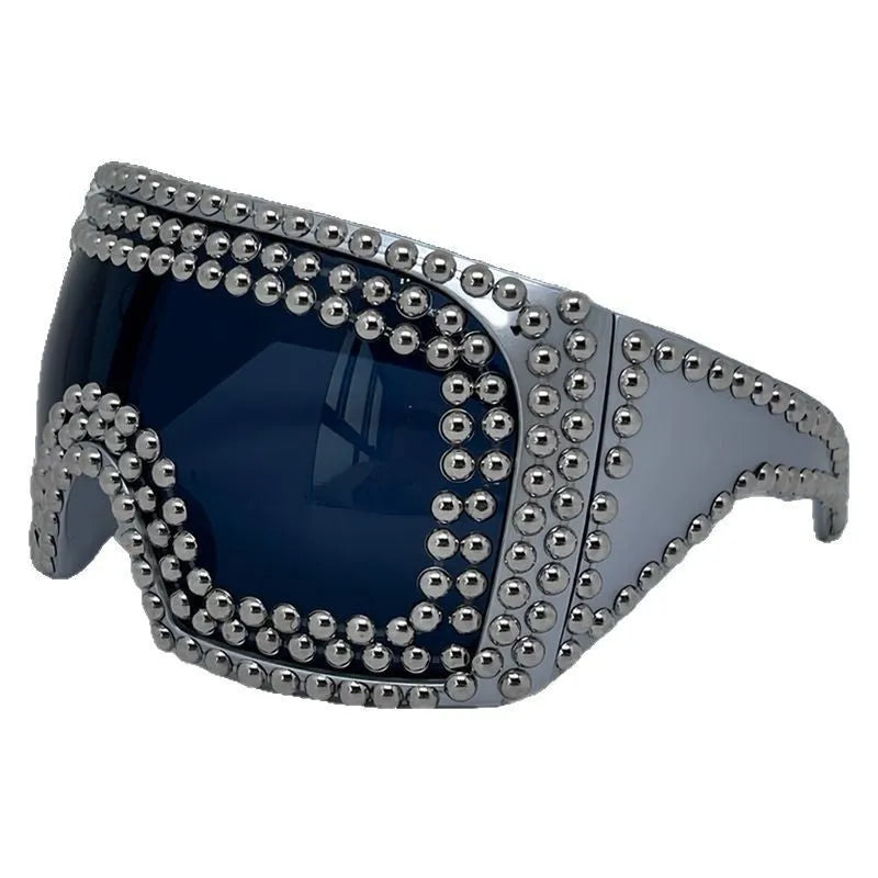 Men's square punk sunglasses with large rim and silver rivets on a dark background.