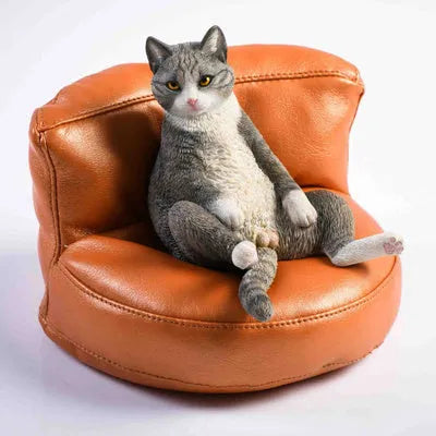 Resin lazy cat car ornament with fabric sofa, approximately 7.5cm high.