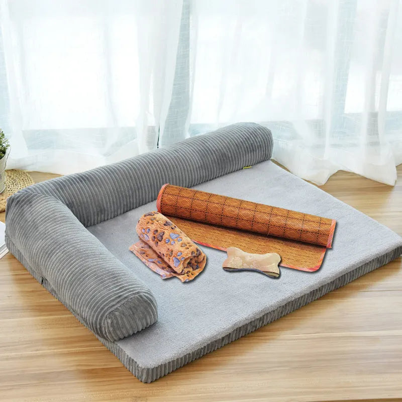 A corduroy pet sofa dog bed with bolsters, shown in a grey colour, placed on a hardwood floor.