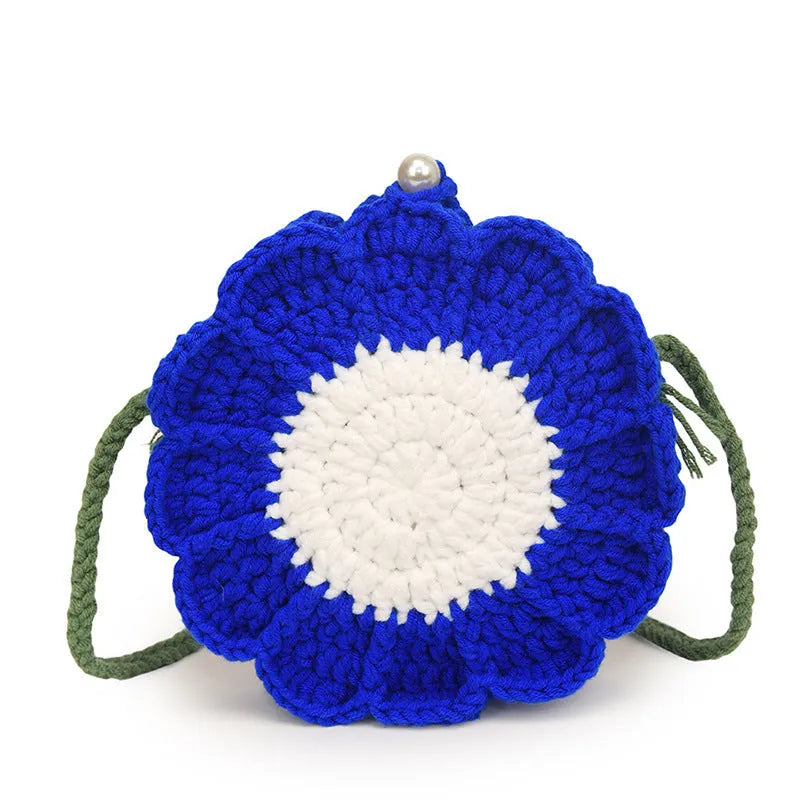 Hand-woven wool crochet bag with flower detailing and round suitcase shape showing internal mobile phone pocket