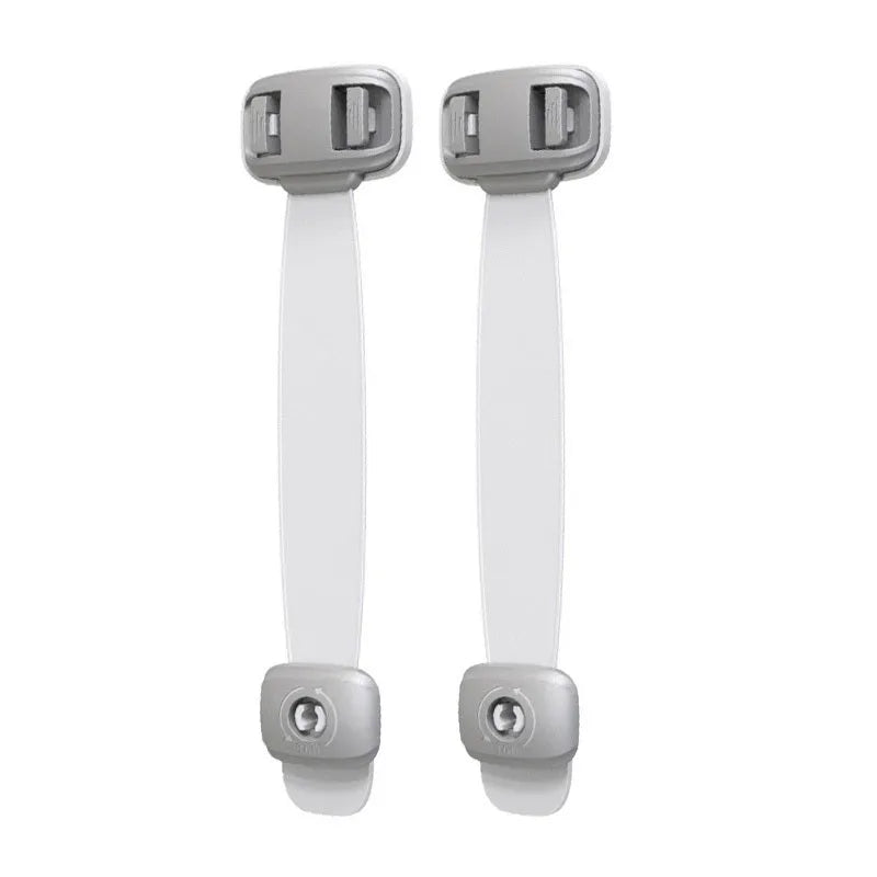 Grey and green adjustable child safety cabinet locks with adhesive backing on a kitchen drawer.