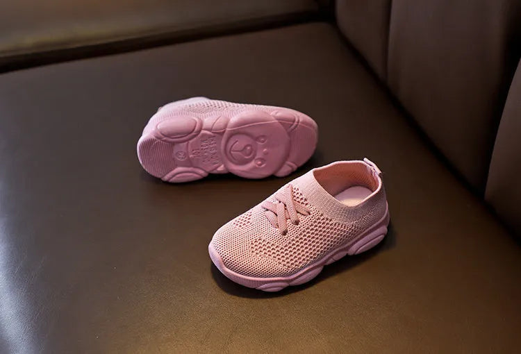 Children's fabric lazy shoe with a non-slip rubber sole, shown in colour options of white, black, pink, and grey.