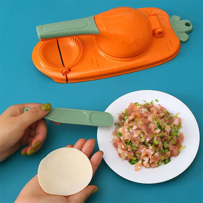 Orange and white plastic manual dumpling press tool with ergonomic handle on a kitchen worktop.
