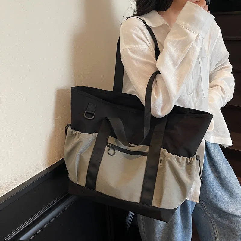Lightweight Oxford cloth travel bag for women in grey, shown with a letter-pattern lining and holding a yoga mat.