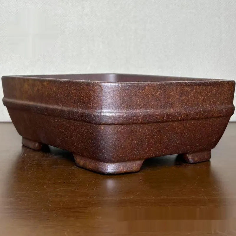 Light brown rectangular ceramic bonsai flower pot on a wooden surface