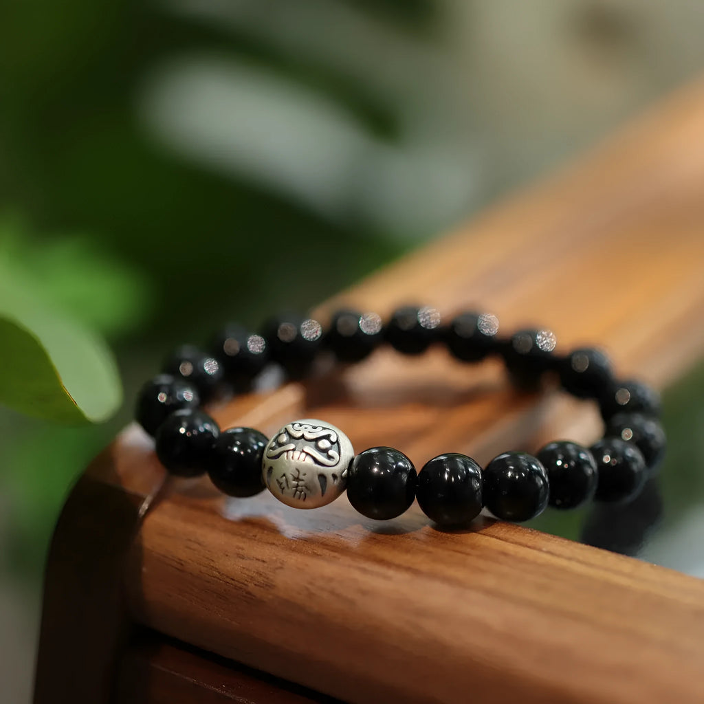 Close-up of a women's bracelet with a large 10mm black agate bead and sterling silver clasp in a Chinese style design.