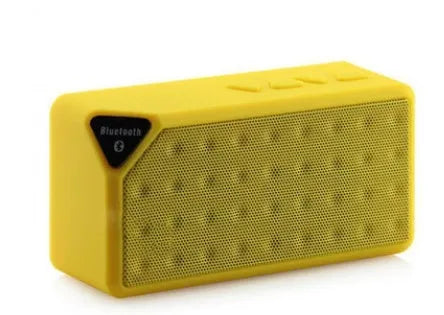 Cannon X3 small cube-shaped portable Bluetooth speaker in various colours on a surface.