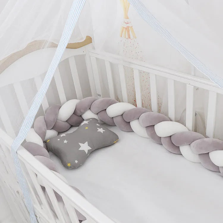 Bendable braid knot baby crib bumper in spandex velvet fabric on a white cot.