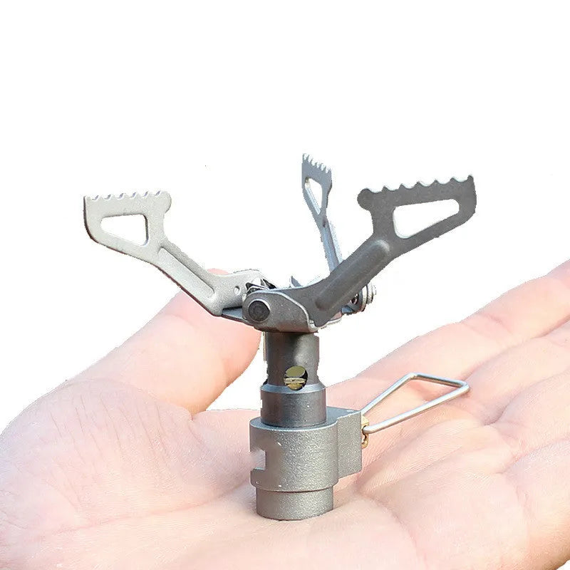 Silver portable propane camping stove with one-piece burner unit on a flat surface.