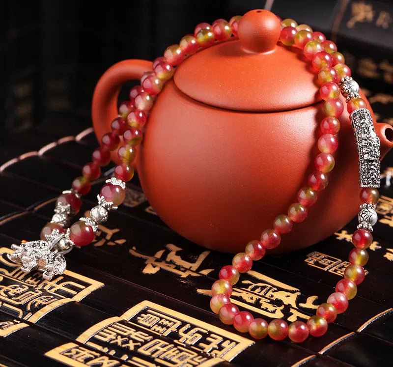 Watermelon crystal bracelet with Chinese knot design showing elephant style beads in geometric shape