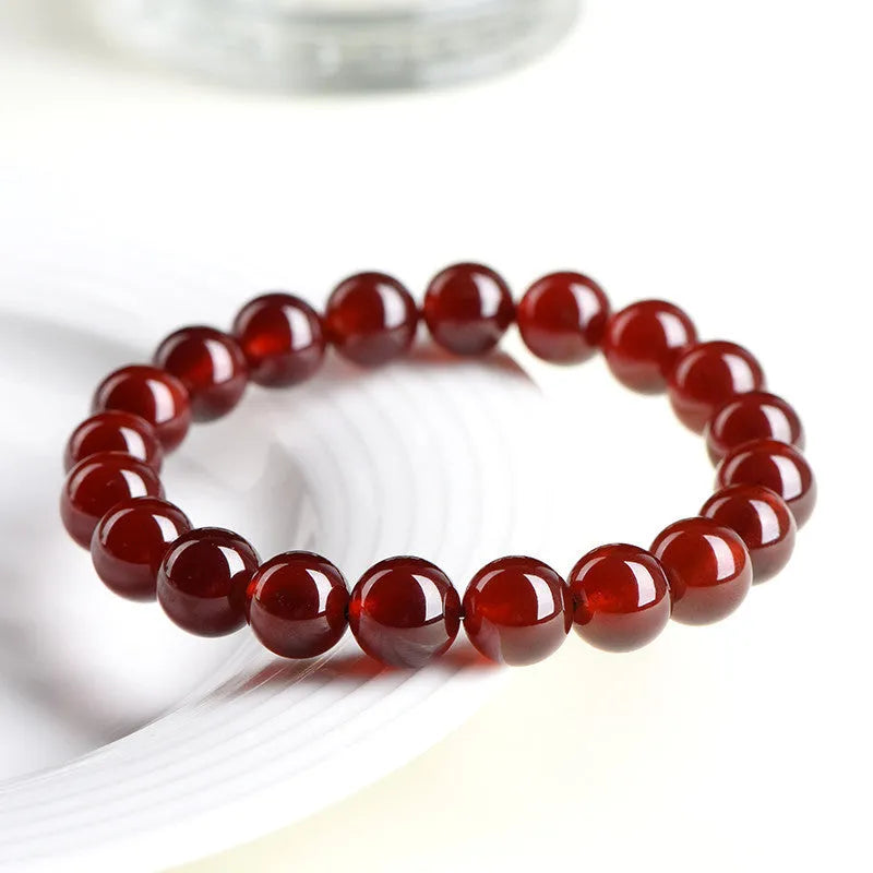 Orange red garnet crystal ball bracelet with retro ruyi design on a wrist