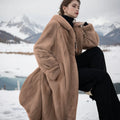 Long brown leopard print faux fur coat on a hanger, showing its loose plus-size fit and full length.