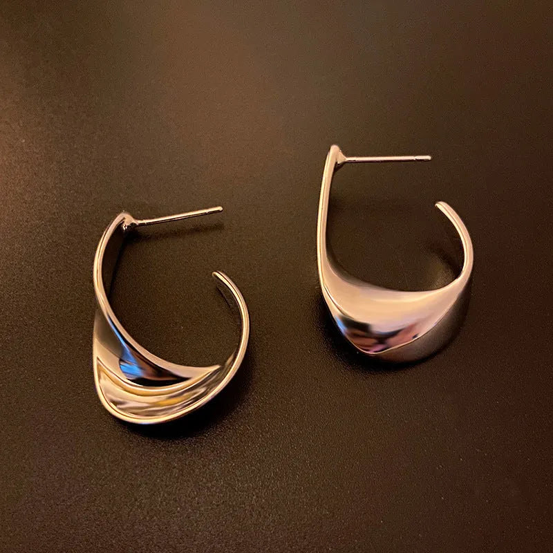 Twisted geometric metal earrings with round element in gold or silver electroplated finish